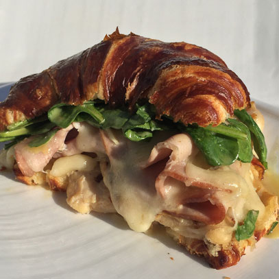 Pretzel Croissant Sandwich.  Gluten-free and nitrate-free grilled chicken breast and ham, Swiss cheese and fresh spinach smothered in honey mustard and chive aioli, grilled and served hot on a pretzel dough croissant or gluten-free toast