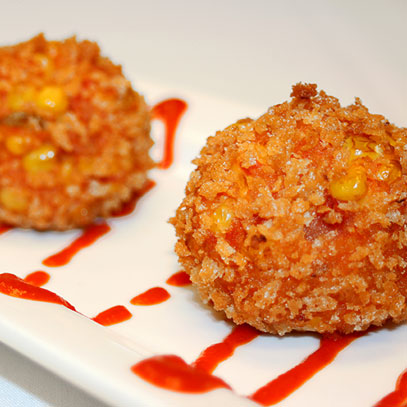 Sriracha Balls.  Two choices of filling breaded in panko, deep-fried and drizzled with Sriracha sauce: blend of shredded chicken, corn, tomatoes, egg and Sriracha; or Sriracha cream cheese with corn, tomatoes and egg