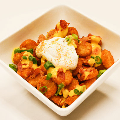 Totchos.  Tater tots smothered in cheddar cheese sauce with seasoned sour cream, bacon bits and green onions (chicken or taco-style beef optional). Gluten-free