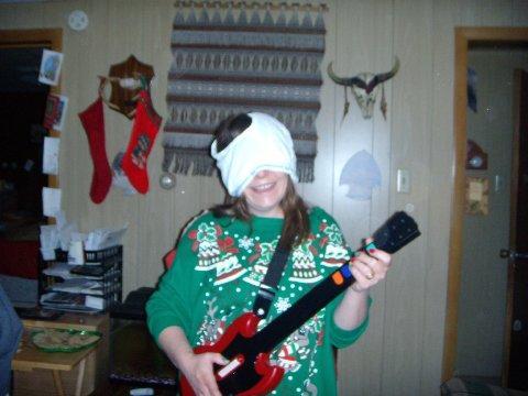 Funny woman wearing underwear on her head and playing guitar hero on christmas