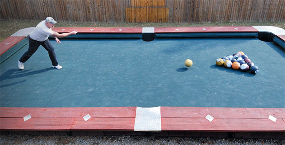 Steve Wienecke, a former semi-pro football player and cage fighter, who has designed and built the Knokkers. It looks like the pool table.  But instead of billiard balls it uses bowling balls. And the table is scaled up 4X its original size, allowing, and requiring, players to stand on it. The first  playable version was built in his backyard in Fr