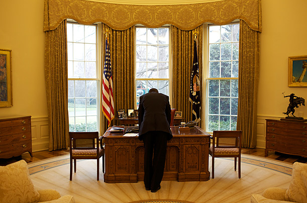 The President reads a document in the Oval Office