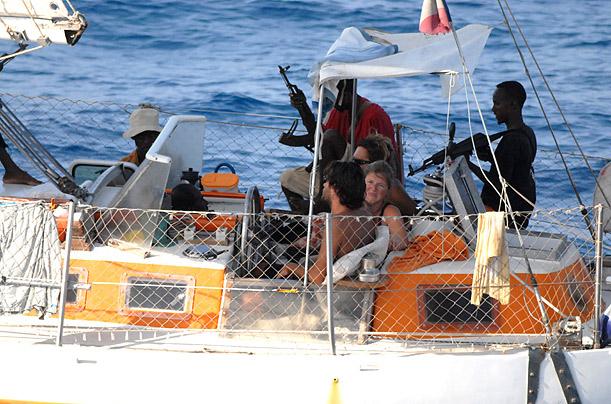 Armed pirates stand over their French hostages