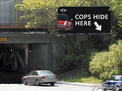 cop hides behind sign