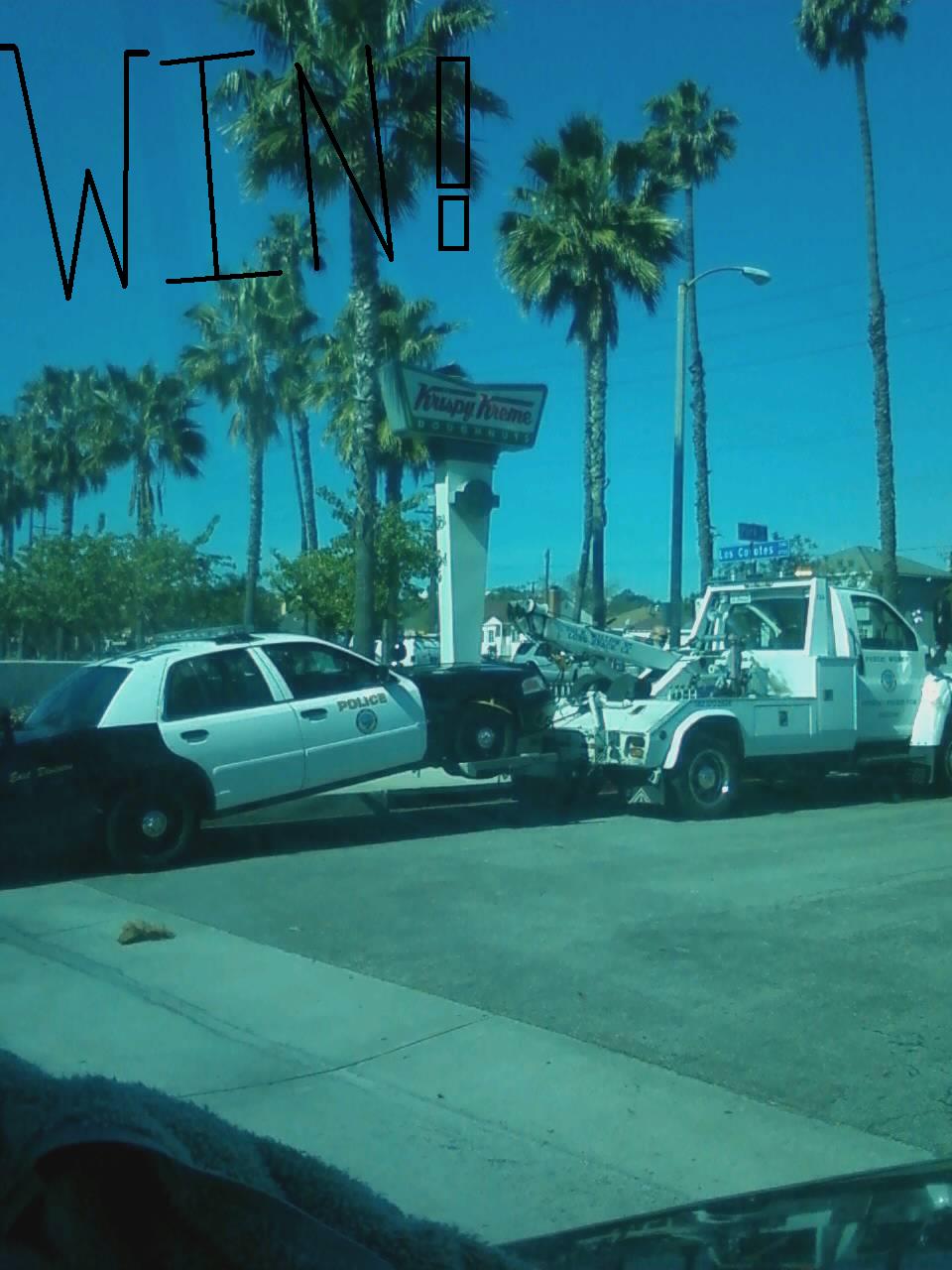 Cop getting towed outside krispy kreme.