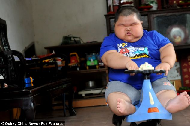 Fat Asian kid on a toy scooter.