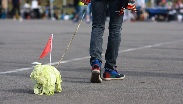 A series of photos online show groups of teens in Beijing trailing the leafy vegetables behind them on leashes.