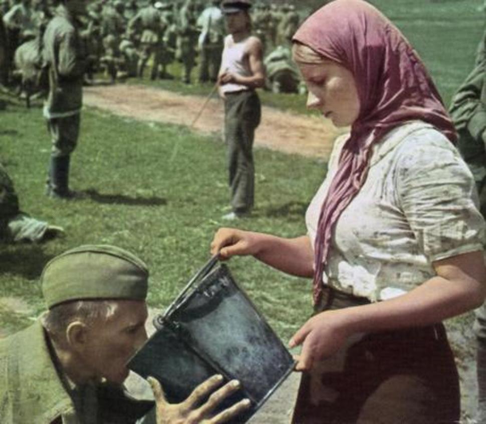 soviet soldier is given water by ukrainian woman