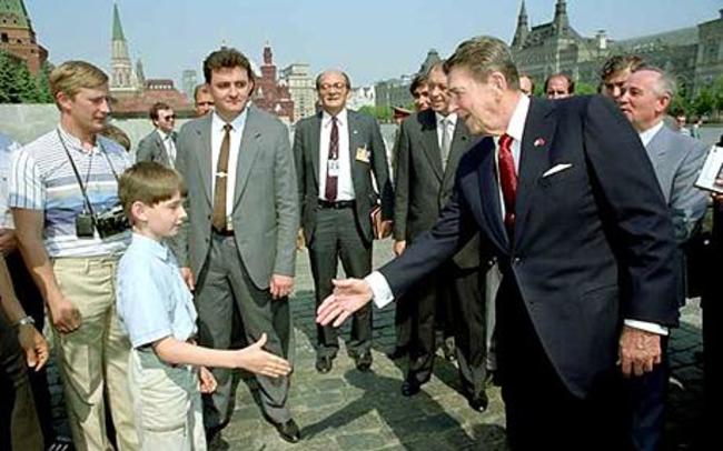 Vladimir Putin (far left) as a young KGB spy, meeting Ronald Reagan. -He was disguised as a member of a tourist party and instructed to harangue Ronald Reagan over his human rights record on the President's first trip to Moscow.
