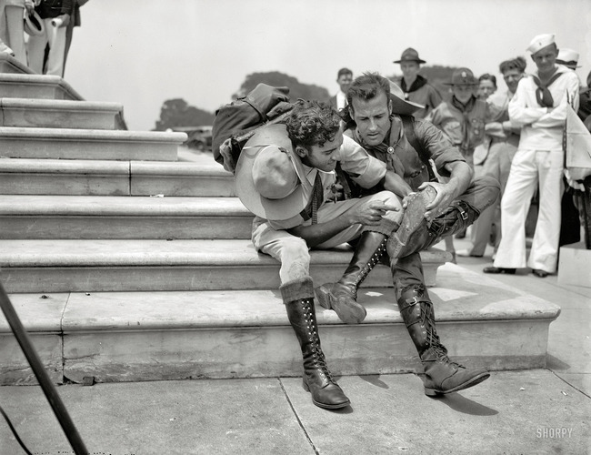 Boy Scouts examine their boots after an 8,000 mile hike to attend the first Boy Scout Jamboree. They walked 25 miles a day for two years. [1937]