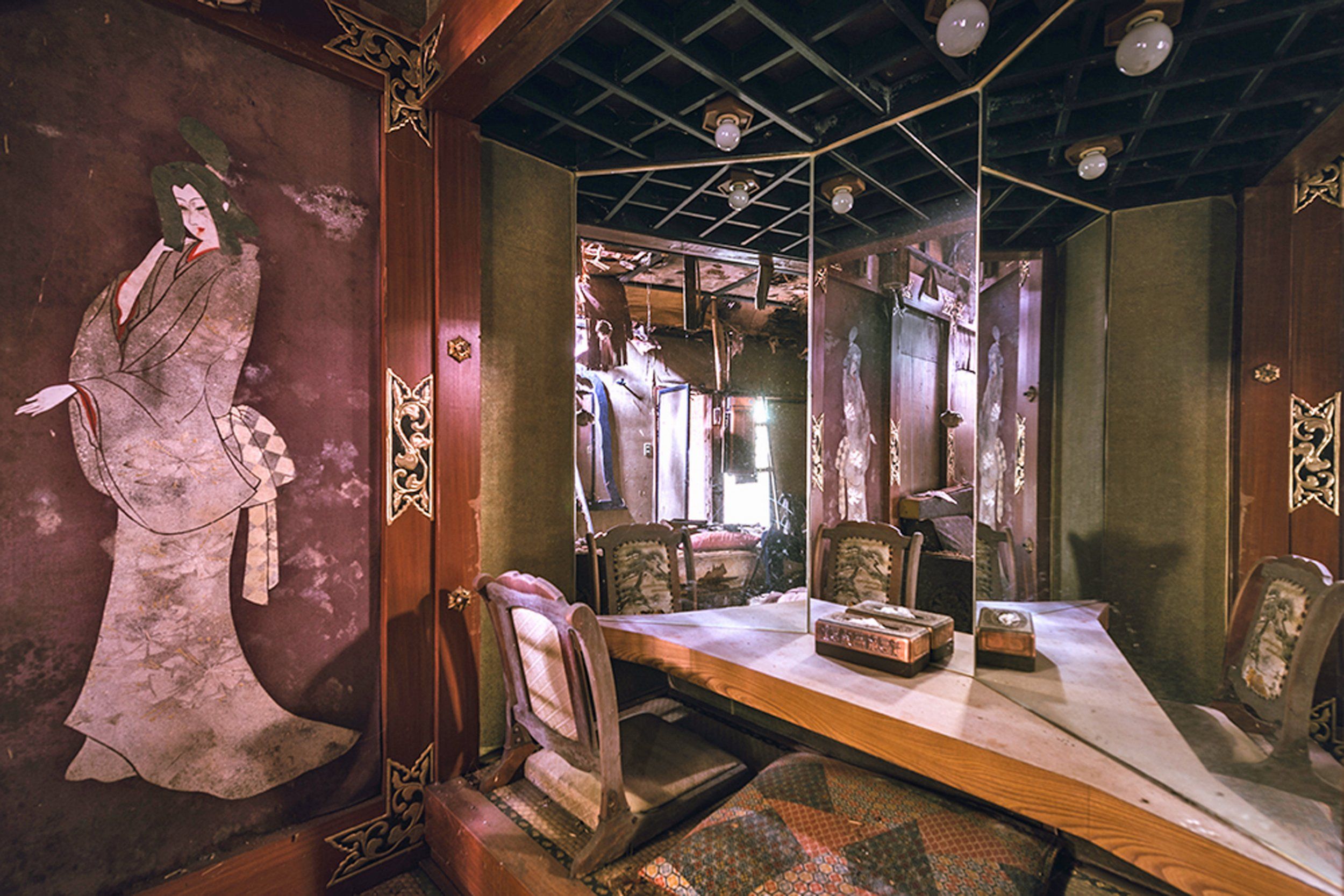 There are ten themed rooms in the hotel, and many had traditional Japanese touches. Pictured, a decaying wall painting of a woman and embroidered chairs.