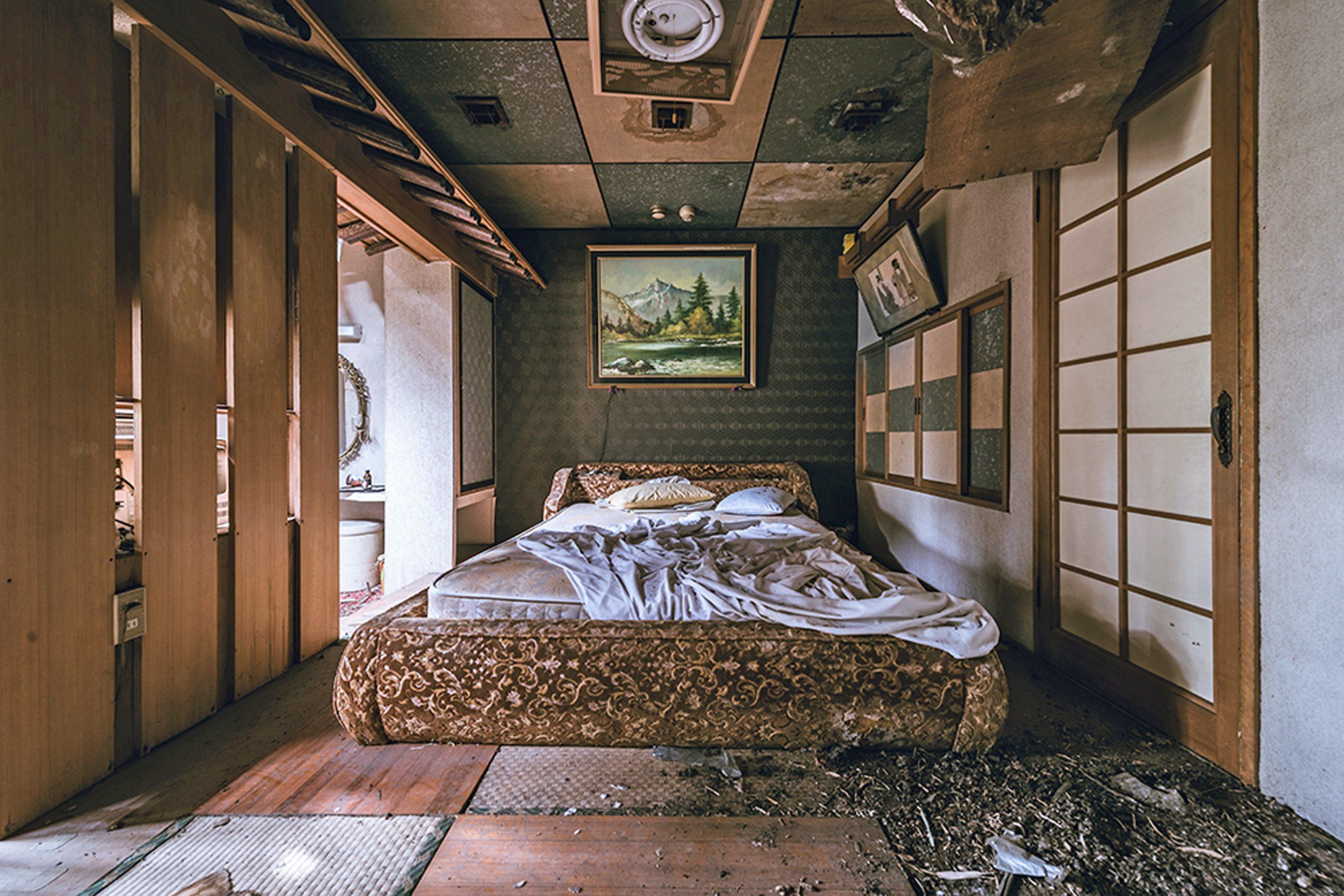 Pictured, a rotting embroidered bed sits in an alpine-themed room
