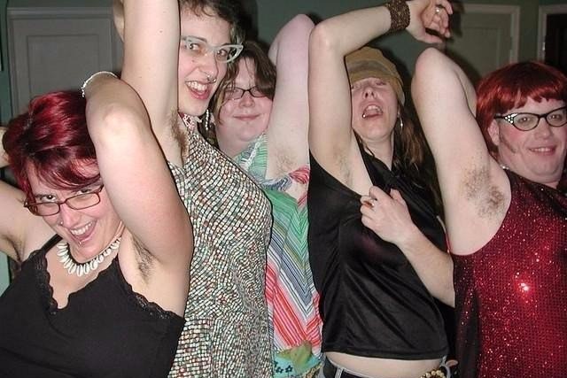 Girls showing off their armpit hair as they dance with no men on the dance floor.