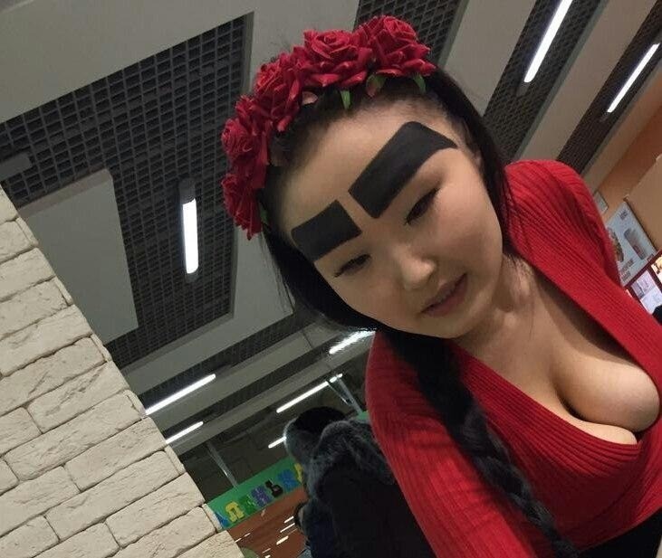 Woman with enormous eyebrows painted on.