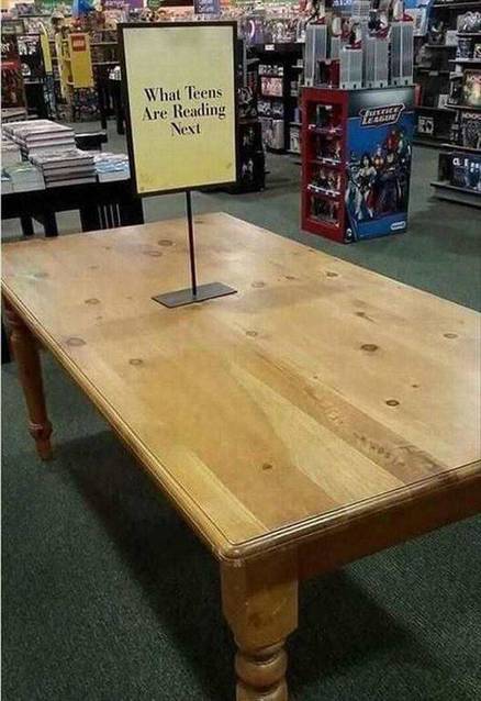 Empty table with a sign declaring this is what kids are reading these days.