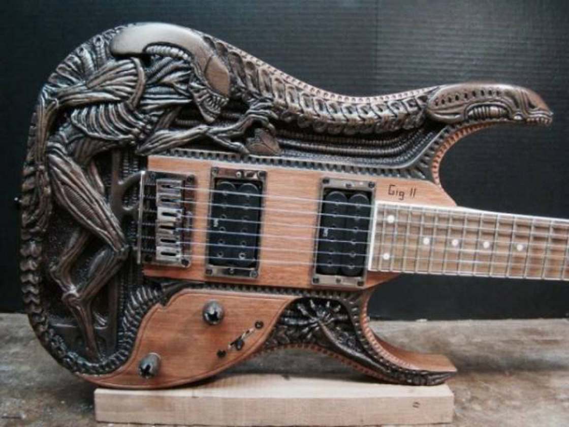 Awesome guitar with an alien xenomorph carved into it.