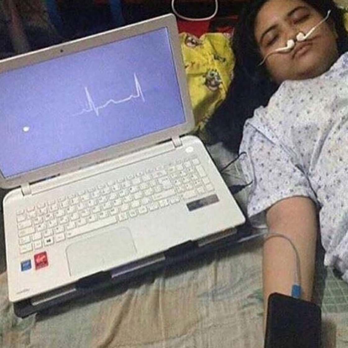Girl who looks like she is dying but upon closer inspection it is just a computer screen and her phone and the nose pieces are her headphones.