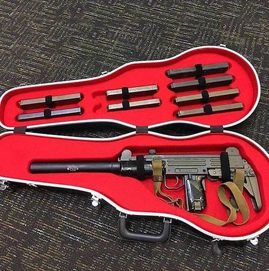 Guitar case that has an Uzi sub-machine-gun with a silencer in it and a whole bunch of clips.