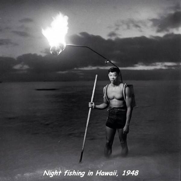 Man with torch mounted on his back to help with night fishing in Hawaii in 1948