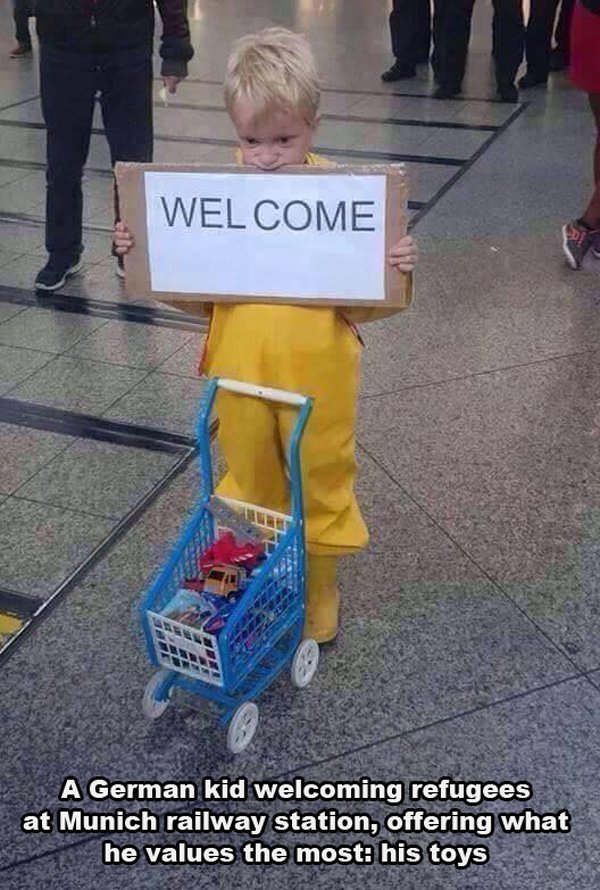 Welcome A German kid welcoming refugees at Munich railway station, offering what he values the most his toys
