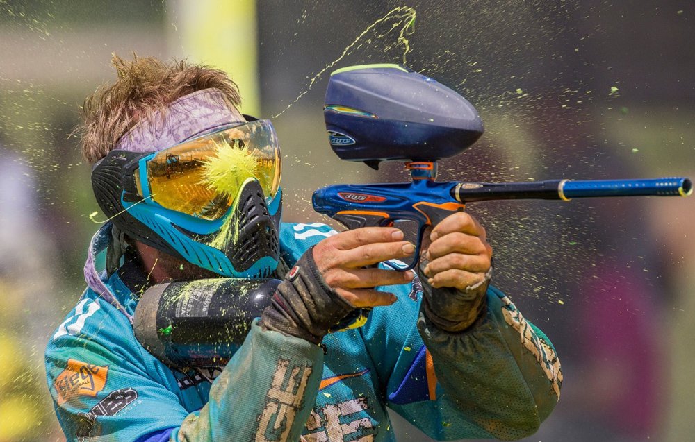 Man playing paintball getting nailed right between the eyes.