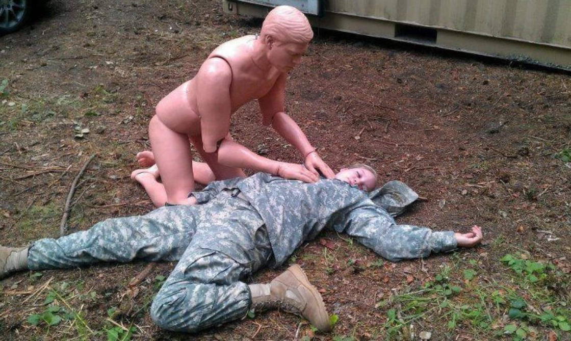 Mannequin giving CPR to a soldier.