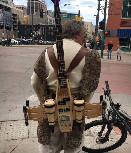 Man dressed as a Jedi carrying an X-wing guitar
