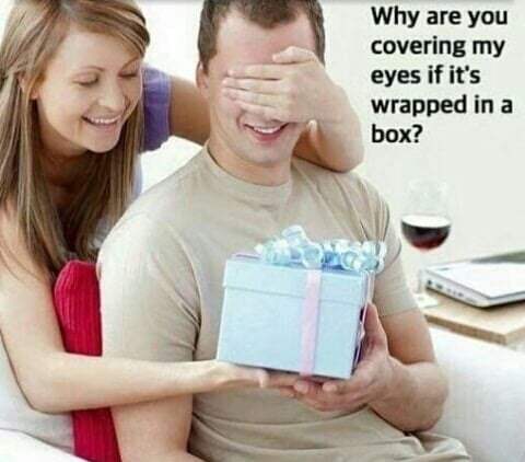 Questionable stock photo of woman covering man's eyes to give him a gift, caption asks why are his eyes covered if she wrapped the gift.