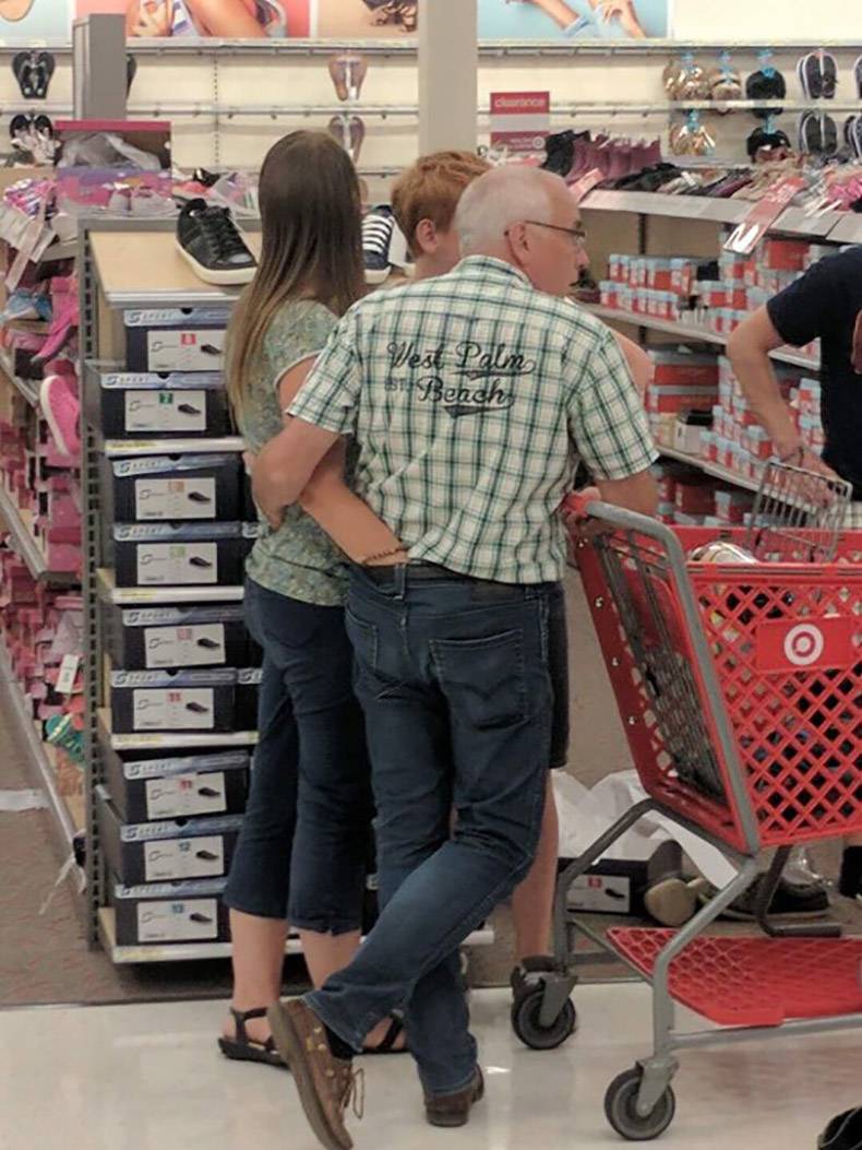 Couple waiting at Walmart with hands down the other's pants.