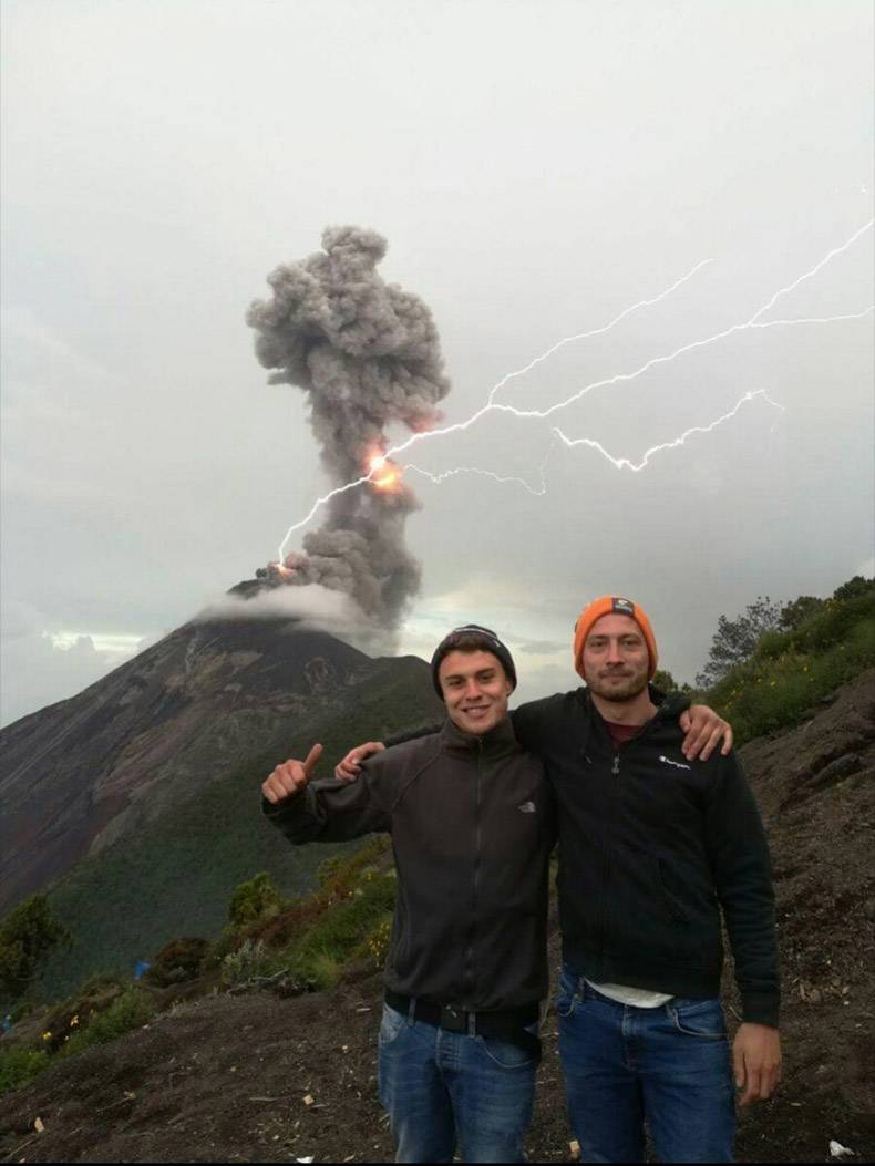Bros hanging out and taking pic in front of exploding volcano