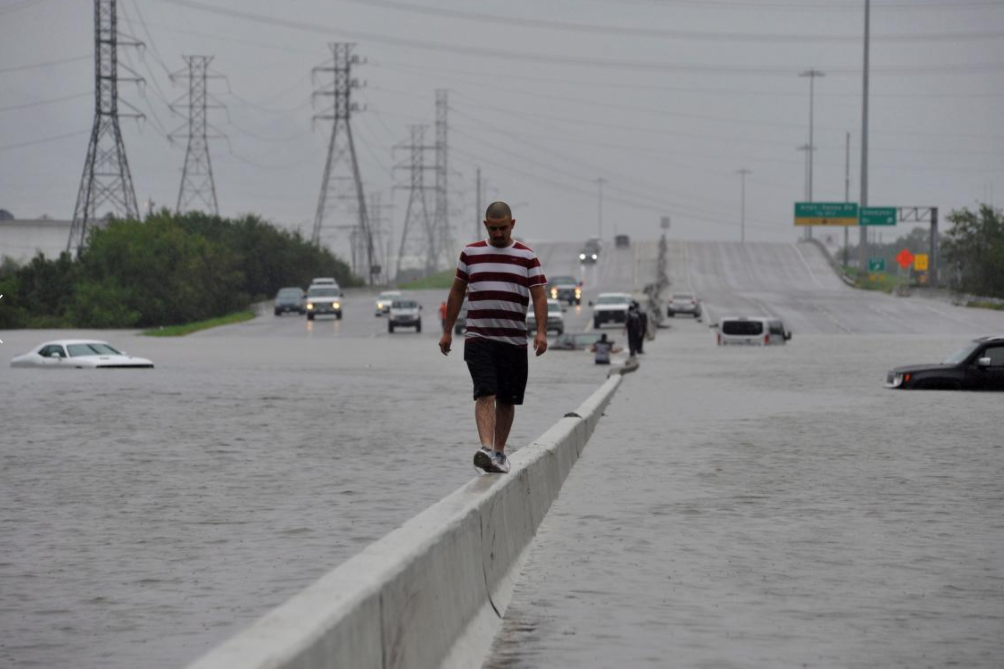 Man walks on highway divided to stay dry in aftermath of Hurricane Harvey
