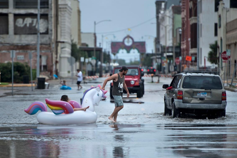 Man pulling girl across flooded street in unicorn boat after Hurricane Harvey