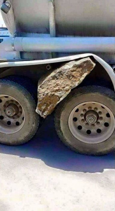 cool pic of a large boulder stuck in a truck tire well