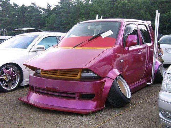 Tricked out car with pink pain and broken wheels