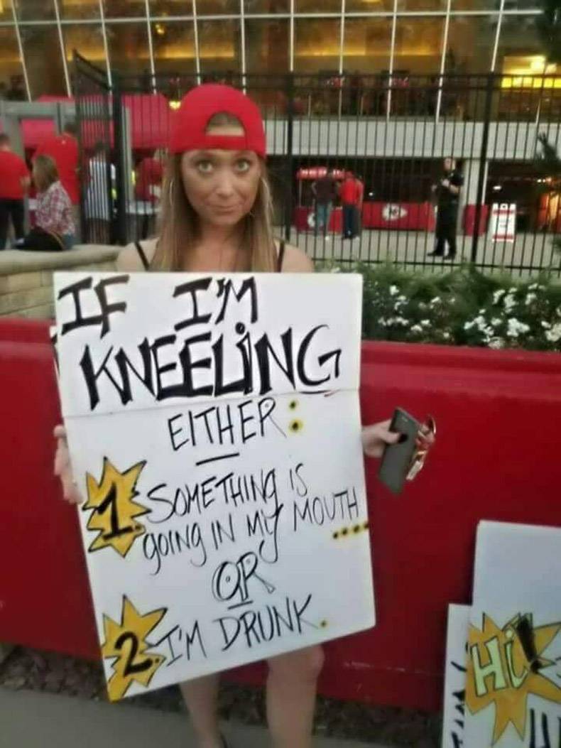Woman holding a funny sign about the only reasons she is kneeling