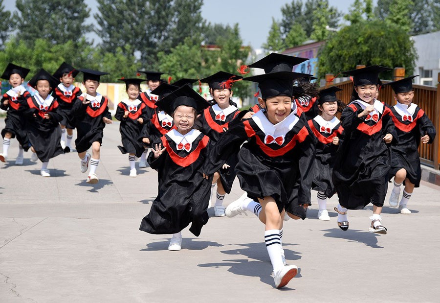 Children in gowns and mortarboards run with smiles during their kindergarten graduation ceremony in Handan, Hebei province, China, on June 20, 2017.