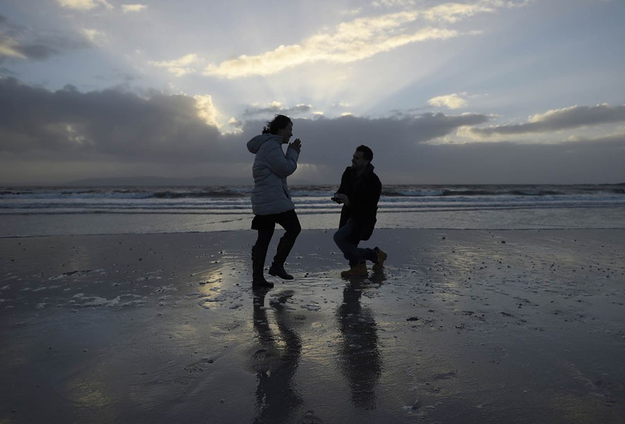 Stephen Donnellan from Galway (right) proposes to his girlfriend Julee Range, from the U.S., on a windy Silverstrand Beach, in Galway, Ireland, on December 23, 2016. The couple, who have been together for five years and live and work in China, arrived back in Donnellan's hometown on Friday, where he subsequently proposed. His proposal of marriage was accepted.