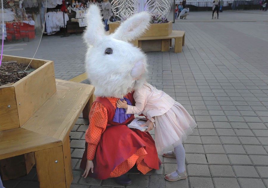 A child hugs an entertainer wearing a rabbit costume at an Easter fair in Bucharest, Romania, on April 13, 2017.