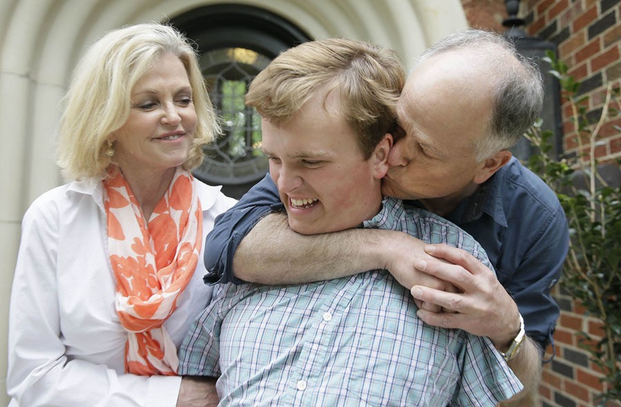 Clay Heighten, right, and Debra Caudy, left, embrace their autistic 19-year-old son Jon Heighten, as they pose for a photo at their home in the Dallas area town of University Park, Texas. Jon Heighten's parents are helping lead a 29-acre housing development and community for autistic adults that will break ground in the coming months. The couple formed a nonprofit called 29 acres and they have raised more than $1 million in donations so far.