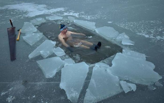 funny picture of a man who axed his way to take a dip in the ice