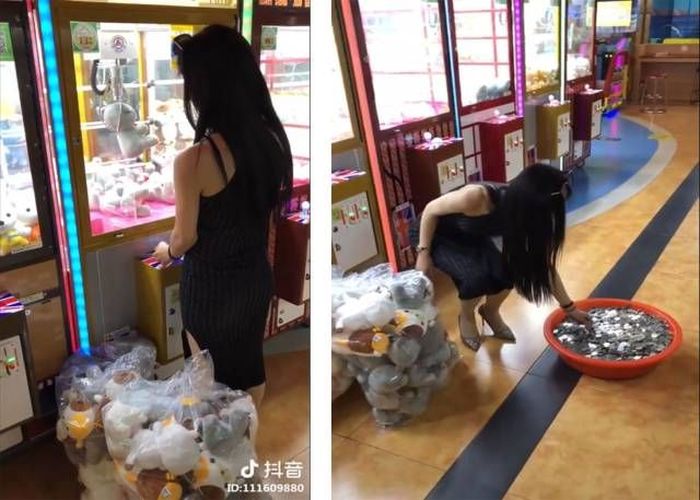 girl with bucket of coins using claw machine to score bags of stuffed animals