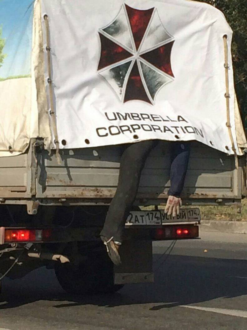 Funny picture of a truck with Umbrella Corporation and a body falling out the back