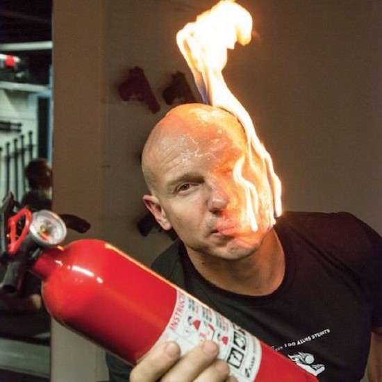 man with face of fire holding a fire extinguisher