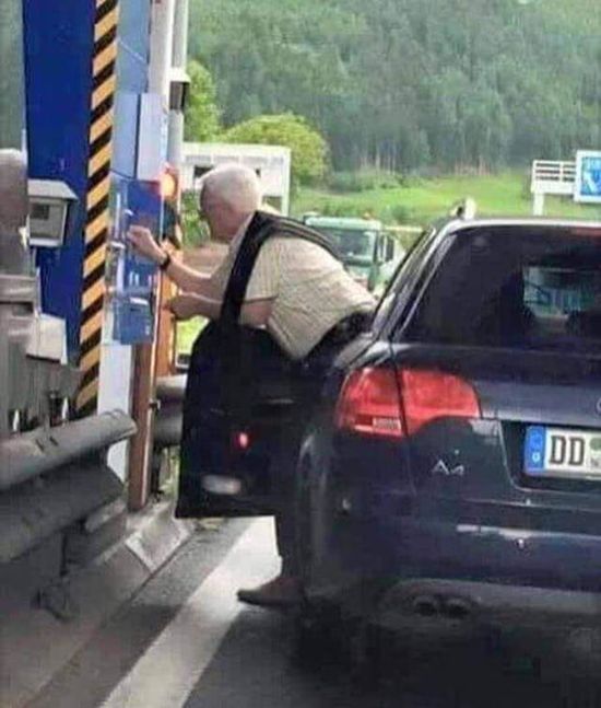 old man entangled with his car door trying to pay the gas machine