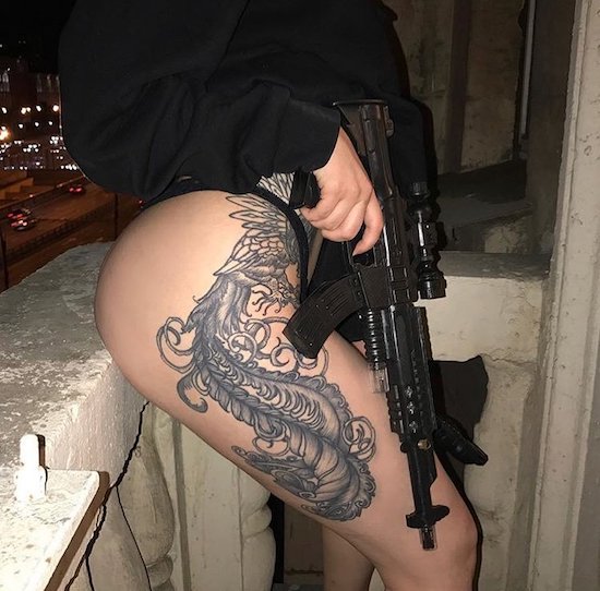 hot girl with badass tattoo holding an automatic weapon