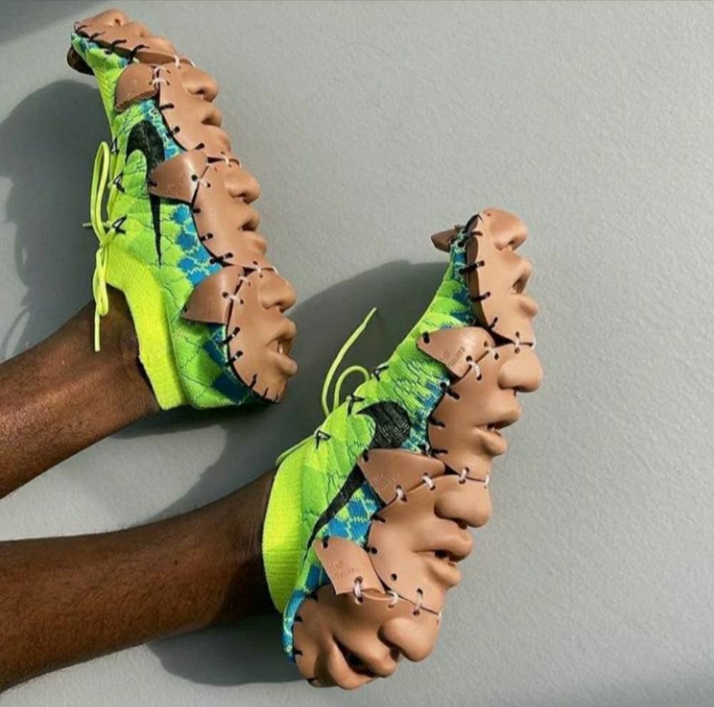green running shoes with doll faces sewn to the bottom