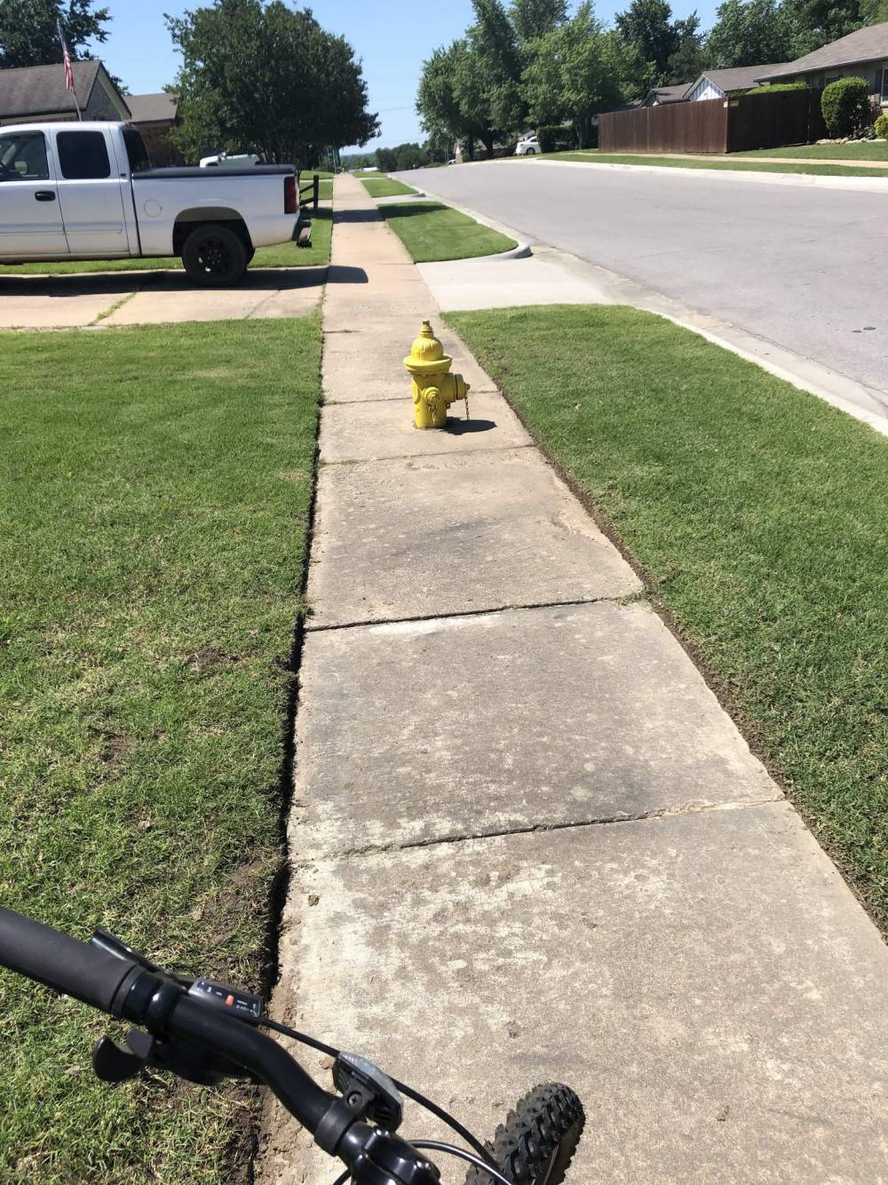 tiny yellow fire hydrant in the middle of the sidewalk