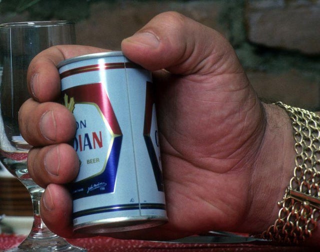 Andre the giant holding a regular sized can of beer!