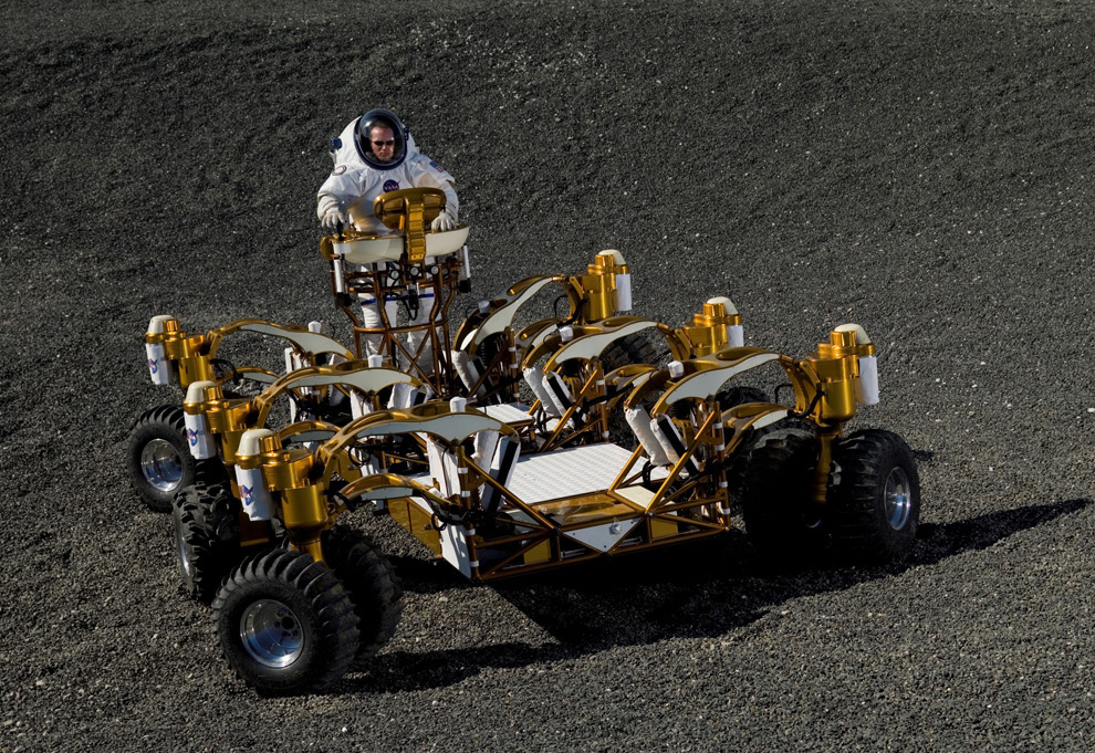 Spacesuit engineer Dustin Gohmert drives NASA's new lunar truck prototype through the moon-like craters of Johnson Space Center's Lunar Yard. The lunar truck was built to make such off roading easy, with six wheels that can be steered independently in any direction. In addition, the steering center can turn a full 360 degree, giving the driver a good view of what's ahead, no matter which way the wheels are pointing. (NASA/JSC) #