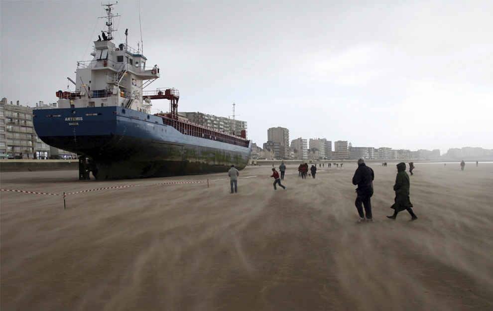 Locals and tourists walk around the Dutch ship Artemis which ran aground on the beach of les Sables d'Olonne, southern French Britanny, western France, March 10, 2008. The boat had been driven onto the coast by the wind blowing more than 130 km per hour. (REUTERS/Stephane Mahe) #